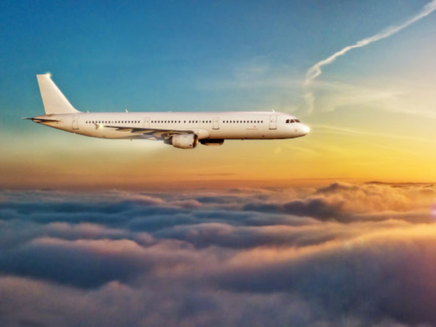 fliegendes Flugzeug bei Sonnenuntergang